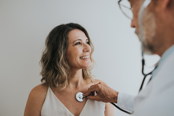  Doctor listening to patient's heart with stethoscope