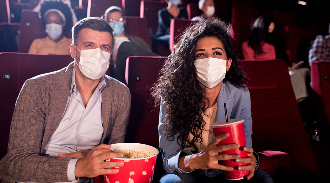 Masked man and woman at the movies 
